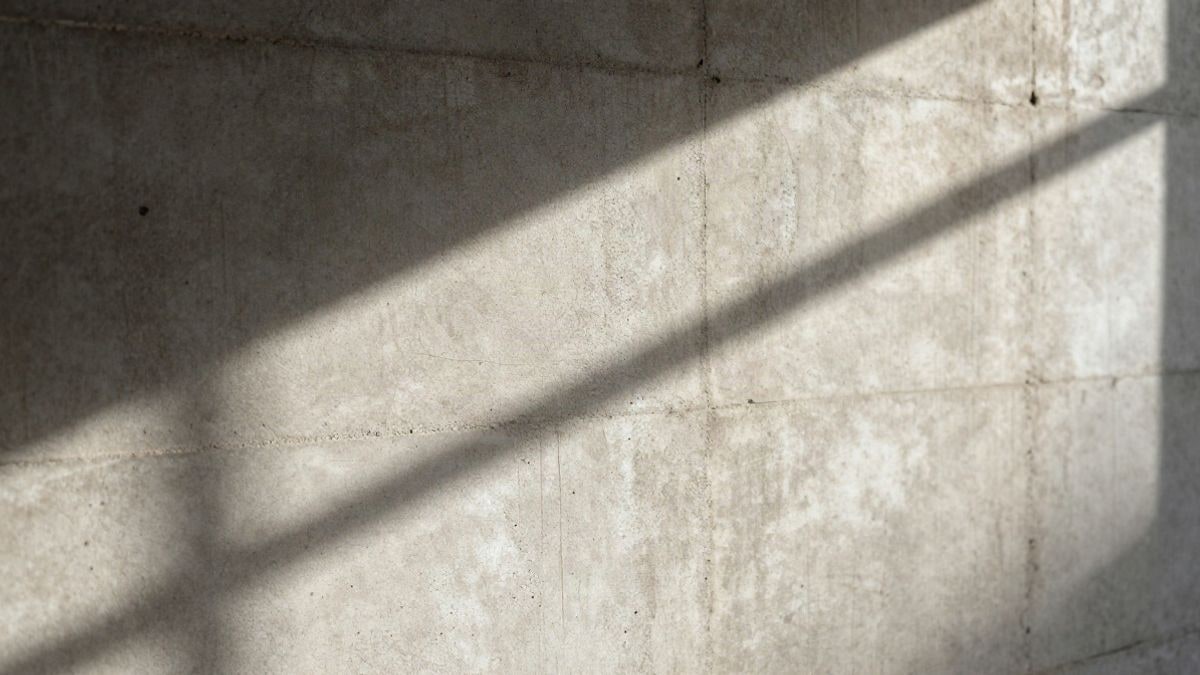 Imagen ilustrativa: detalle de una pared de hormigón agrietada con luz natural dramática