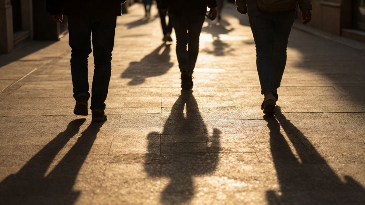 Illustrative image: backlight at sunset with silhouettes and long shadows on a street with an ATM