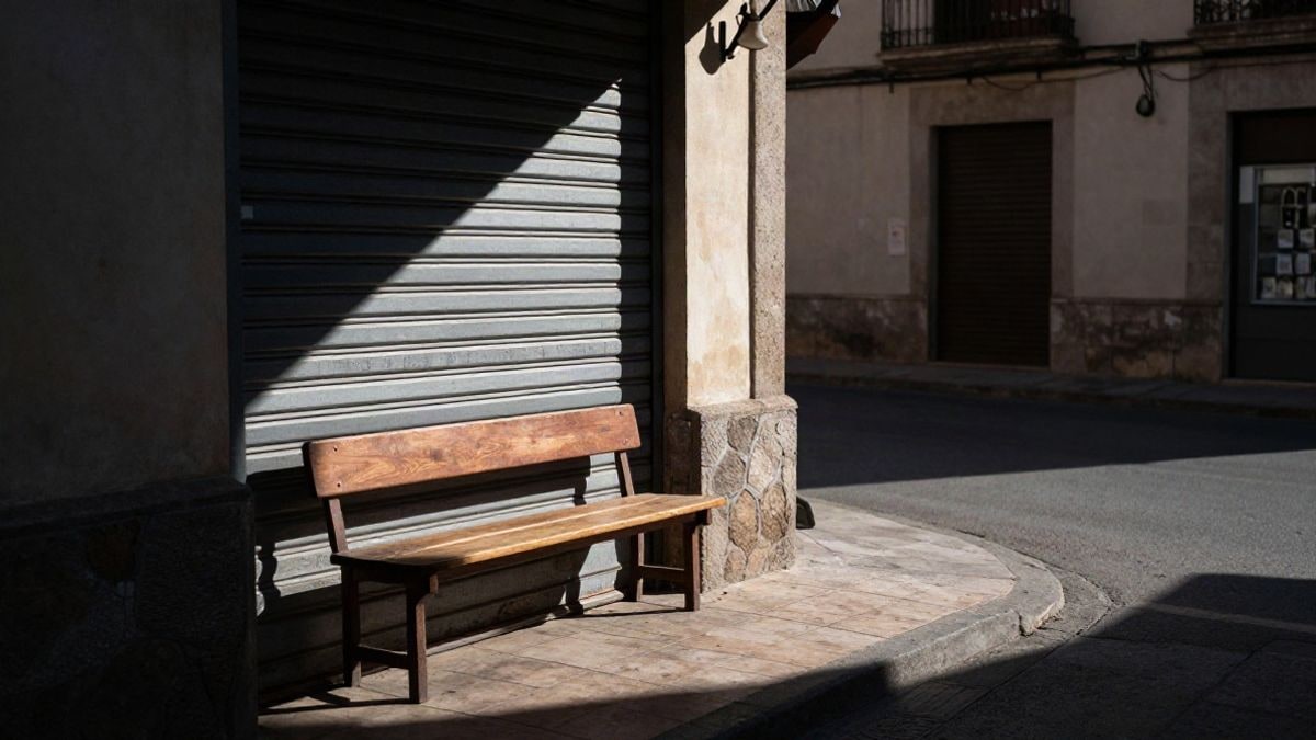 Illustrative image: a small commercial premises with the shutter down on a quiet street in a village at sunset
